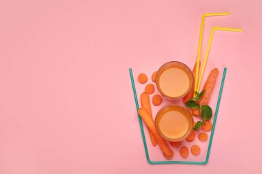 Renkli arka planda havuç suyundan yapılmış bir bardak. Minimalizm tasarım konsepti. Üst görünüm, Spac kopyala