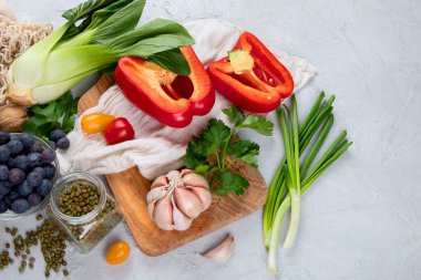 Açık gri arka planda taze çiğ sebze, meyve ve fasulye seçimi. Organik gıda konsepti. Üst görünüm, alanı kopyala