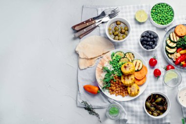 Açık gri arka planda servis edilen soslu ve abur cuburlu nefis ızgara sebzeler. Barbekü menüsü. Üst görünüm, alanı kopyala