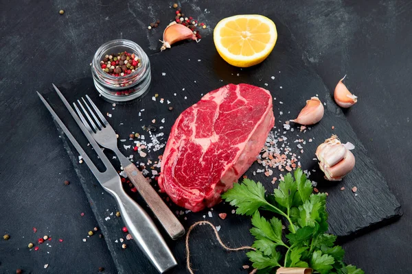 Bistecche Crude Carne Con Condimento Erbe Aromatiche Fondo Scuro Concetto — Foto Stock