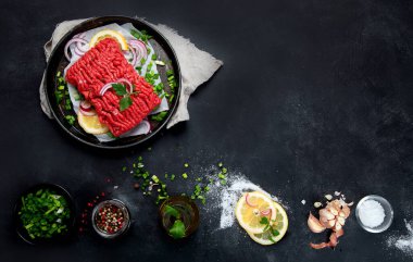 Baharatlı, sebzeli ve koyu renkli otlu çiğ et. Yemek pişirme konsepti için malzemeler. Üst görünüm, alanı kopyala