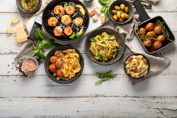 意大利面团配上传统小吃和酱料 在白色木制背景上享用晚餐 自制食品的概念 顶部视图 复制空间 — 图库照片