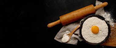 Wheat flour on dark background. Food preparing concept. Top view, copy space, panorama