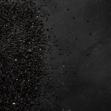 Black sesame seed on black background. Organic food concept. Top view, Copy spac