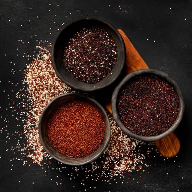 Koyu arkaplandaki farklı kinoa tipleriyle ayarlayın. Organik gıda konsepti. Üst görünüm