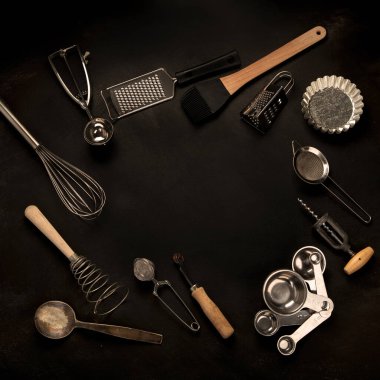 Siyah arka planda mutfak gereçleri. Yemek pişirmek için aletler. Üst görünüm, alanı kopyala