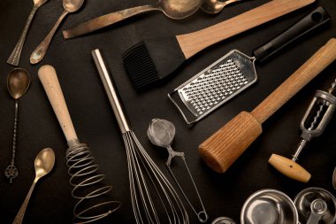 Siyah arka planda mutfak gereçleri. Yemek pişirmek için aletler. Üst görünüm, alanı kopyala