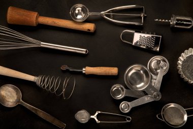 Set of kitchen utensils on black background. Tools for cooking. Top view