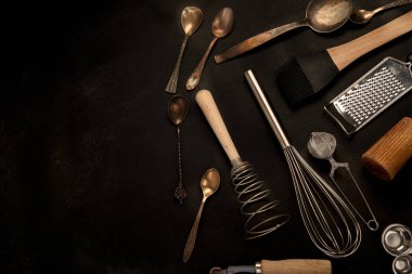 Siyah arka planda mutfak gereçleri. Yemek pişirmek için aletler. Üst görünüm, alanı kopyala