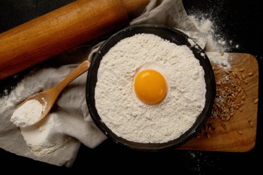 Wheat flour on dark background. Food preparing concept. Top view