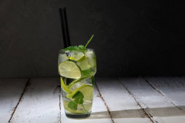 Fresh made Mojito cocktail on dark background. Summer drinks concept. Front view, panorama