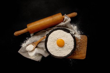 Wheat flour on dark background. Food preparing concept. Top view, copy space
