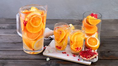 Refreshing orange lemonade on grey wooden table. Summer drinks concept. 