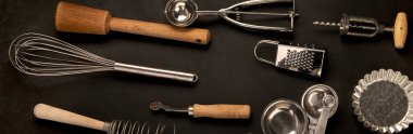 Set of kitchen utensils on black background. Tools for cooking. Top view, copy space, panorama