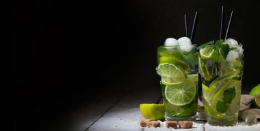 Koyu arkaplanda taze Mojito kokteyli. Yaz içkileri konsepti. Ön görünüm, boşluk kopyala, panorama