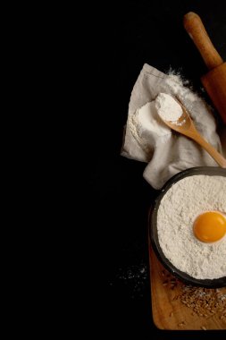 Wheat flour on dark background. Food preparing concept. Top view, copy space
