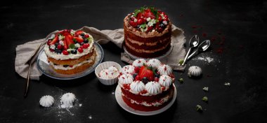 Çeşitli lezzetli ve renkli ev yapımı kekler. Siyah arka planda farklı dolgu çeşitleri var.. 