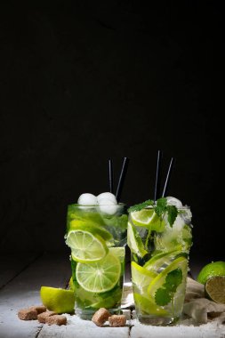 Koyu arkaplanda taze Mojito kokteyli. Yaz içkileri konsepti. Ön görünüm, boşluğu kopyala
