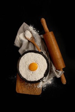 Wheat flour on dark background. Food preparing concept. Top view