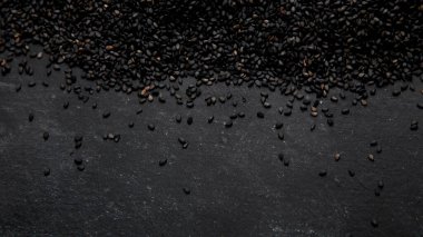 Black sesame seed on black background. Organic food concept. Top view, Copy spac
