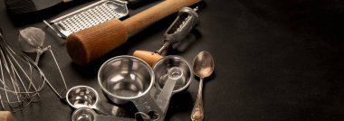 Set of kitchen utensils on black background. Tools for cooking. Panorama