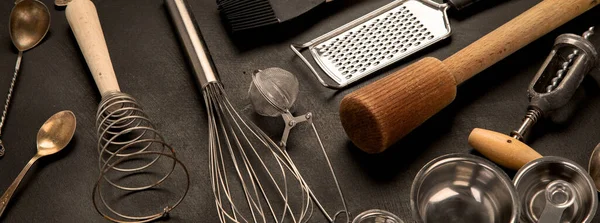 Set of kitchen utensils on black background. Tools for cooking. Panorama