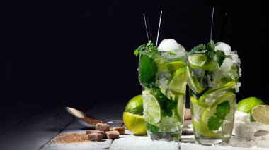 Koyu arkaplanda taze Mojito kokteyli. Yaz içkileri konsepti. Ön görünüm, boşluk kopyala, panorama