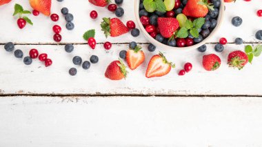 Beyaz arka planda çeşitli taze orman meyveleri. Organik gıda konsepti. Üst görünüm, alanı kopyala