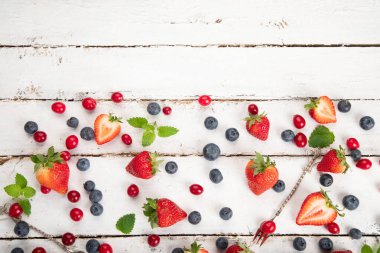 Beyaz arka planda çeşitli taze orman meyveleri. Organik gıda konsepti. Üst görünüm, alanı kopyala
