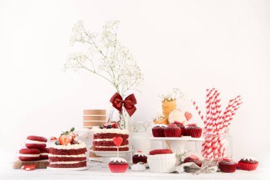 Lezzetli pasta ve kırmızı kapkekler beyaz arka planda. Kutlama için tablo ayarı. 