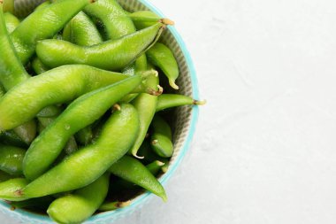Çiğ edamame soya fasulyesi, açık gri arka planda tuz ve sos. Üst görünüm, alanı kopyala