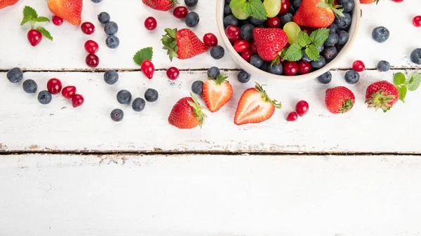Beyaz arka planda çeşitli taze orman meyveleri. Organik gıda konsepti. Üst görünüm, alanı kopyala