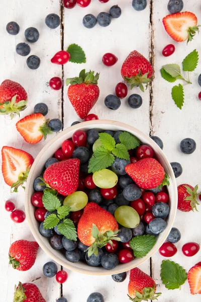 Beyaz arka planda çeşitli taze orman meyveleri. Organik gıda konsepti. Üst görünüm
