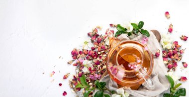 Fincanlı gül çayı ve açık gri arka planda çaydanlık. Üst görünüm, alanı kopyala