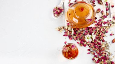 Fincanlı gül çayı ve açık gri arka planda çaydanlık. Üst görünüm, alanı kopyala