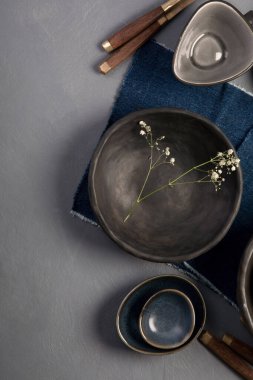 Gri arka planda siyah ve mavi plakalı masa ayarı. Minimalizm kavramı. Üst görünüm, Spac kopyala