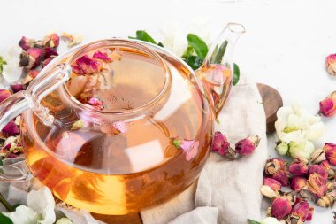 Fincanlı gül çayı ve açık gri arka planda çaydanlık.. 