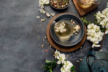 Fincanlı yeşil bitki çayı ve gri arka planda çaydanlık. Üst görünüm, alanı kopyala