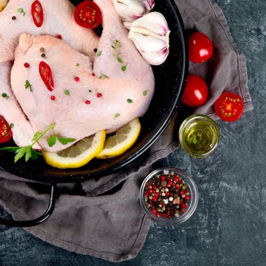 Çiğ tavuk budu, baharat ve gri arka planda pişirmek için bitkiler. Üst görünüm, alanı kopyala