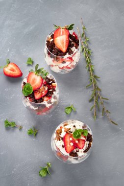 Taze böğürtlenler ve gri arka planda mascarpone kremiyle yapılan ıvır zıvırlar. Porsiyon Tatlıları. 