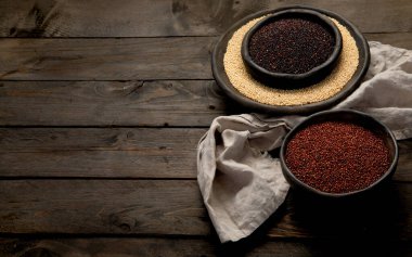 Koyu arkaplandaki farklı kinoa tipleriyle ayarlayın. Organik gıda konsepti. Üst görünüm, alanı kopyala