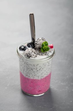 Gri arka planda pembe dolgulu Chia pudingi. Sağlıklı kahvaltı kavramı