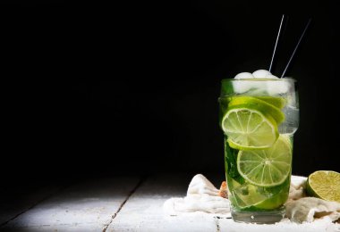Koyu arkaplanda taze Mojito kokteyli. Yaz içkileri konsepti. Ön görünüm, boşluğu kopyala