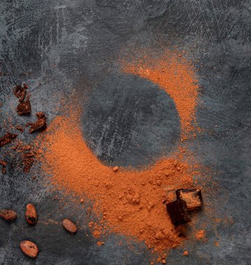 Gri arka planda kakao fasulyesi ve çikolata. Süper yiyecek konsepti. Üst görünüm, düz görünüm, kopyalama alanı