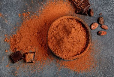 Gri arka planda kakao fasulyesi ve çikolata. Süper yiyecek konsepti. Üst görünüm, düz görünüm, kopyalama alanı