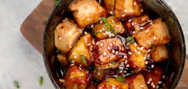 Açık gri arka planda susamlı geleneksel ev yapımı kızarmış tofu. Üst görünüm, düz görünüm, kopyalama alanı, panorama