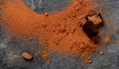 Gri arka planda kakao fasulyesi ve çikolata. Süper yiyecek konsepti. Üst manzara, düz uzanma