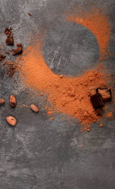 Gri arka planda kakao fasulyesi ve çikolata. Süper yiyecek konsepti. Üst görünüm, düz görünüm, kopyalama alanı