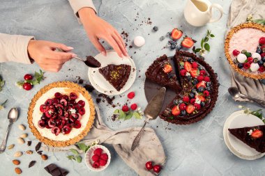 Açık gri arka planda farklı ev yapımı tartlar. Üst manzara, düz uzanma