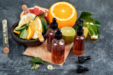 Koyu gri arka planda narenciye aromalı gerekli aroma yağları. Boşluğu kopyala